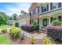 Inviting home exterior featuring a landscaped front yard with colorful bushes and a welcoming front porch at 1265 Kelly Nelson Dr, Lawrenceville, GA 30043