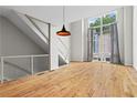Open-concept living space with hardwood floors, modern lighting, and a staircase with metal railings at 1271 Ponti Nw Mews # 92, Atlanta, GA 30318