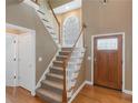 Bright foyer featuring hardwood floors, staircase with white railings, and a decorative front door with glass details at 1605 Little Lisa Ln, Snellville, GA 30078