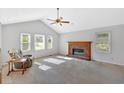 Bright living room with a fireplace, carpeted floor, vaulted ceiling, and large windows at 4807 Willowwood Ne Dr, Kennesaw, GA 30144