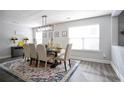 Bright dining room boasts stylish rug, dining set, modern light fixture, and neutral walls at 2210 Valley Creek Dr, Lithia Springs, GA 30122