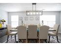 Bright dining room boasts stylish rug, dining set, modern light fixture, and neutral walls at 2210 Valley Creek Dr, Lithia Springs, GA 30122