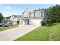 Charming two-story home with a two-car garage, a long driveway, and manicured lawn at 2210 Valley Creek Dr, Lithia Springs, GA 30122