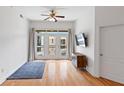 Bright living room features a ceiling fan, wood floors, and access to a private balcony at 390 17Th Nw St # 6036, Atlanta, GA 30363