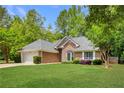 Charming brick home featuring a manicured lawn, two-car garage and a beautifully landscaped front yard at 5850 Shannon Dr, Cumming, GA 30040