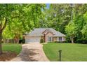 Charming brick home featuring a manicured lawn, two-car garage and a beautifully landscaped front yard at 5850 Shannon Dr, Cumming, GA 30040