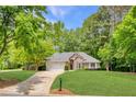Charming brick home featuring a manicured lawn, two-car garage and a beautifully landscaped front yard at 5850 Shannon Dr, Cumming, GA 30040