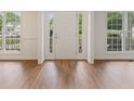 Bright foyer features wood floors, a white front door, and windows on either side at 84 Conner Glenn Dr, Hiram, GA 30141