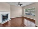 Open living space with a fireplace, ceiling fan, and large window providing abundant natural light at 7120 Oakley Ct, Union City, GA 30291