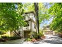 Multi-level home with stone accents, a detached garage, and a driveway surrounded by trees at 138 Garland Ave, Decatur, GA 30030