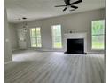 Bright living room with a fireplace, modern gray flooring, and large windows at 2711 Teal Landing Dr, Morrow, GA 30260
