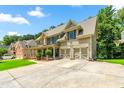 A spacious house features a driveway, multiple car garage, and lush green surroundings at 5652 Harbormist Dr, Powder Springs, GA 30127