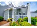 Home exterior featuring light-green siding, white trim, and meticulously maintained landscaping at 325 Berry Ct, Villa Rica, GA 30180