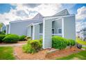 Quaint home exterior with manicured bushes and light-green siding on a sunny day at 325 Berry Ct, Villa Rica, GA 30180