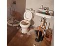 Bathroom with old toilet, sink, and damaged floor at 3448 Orchard Cir, Decatur, GA 30032