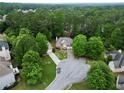 Aerial view of a brick home with lush greenery and a long driveway at 4325 Camellia Ridge Sw Way, Lilburn, GA 30047