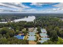 Stunning aerial view of tennis courts and lush landscaping near a lake at 5065 Harbour Ridge Dr, Alpharetta, GA 30005