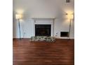 Living room with a fireplace, flanked by lamps, and dark wood floors at 1502 Countryside Se Pl # 1502, Smyrna, GA 30080