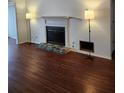 Living room featuring dark wood floors and a fireplace with a stone hearth at 1502 Countryside Se Pl # 1502, Smyrna, GA 30080