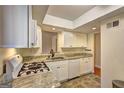 Bright kitchen with white cabinetry, granite countertops, and modern gas stove at 3301 Henderson Mill Rd # J1, Atlanta, GA 30341
