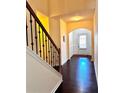 View of the hallway with dark floors and wooden staircase with iron spindles at 3981 Isaac Ct, Lilburn, GA 30047