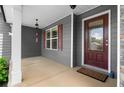 Charming front porch features gray siding, stone accents, and a red front door at 114 Brookstone Dr, Carrollton, GA 30116