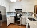 Well-equipped kitchen with white cabinetry, stainless steel appliances, and stylish backsplash at 1461 Fox Forest Sw Ter, Lilburn, GA 30047