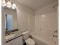 Bright bathroom featuring a shower-tub combo, granite counters, and modern fixtures at 451 Courthouse Park Dr, Temple, GA 30179