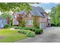 Spacious brick house with an attached three-car garage and a meticulously landscaped front yard at 2118 Town Manor Ct, Dacula, GA 30019