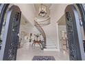 Grand foyer featuring a curved staircase, soaring ceilings, and elegant tile flooring with an ornate entry at 9325 Saint Georgen Cmn, Duluth, GA 30097