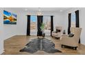 Bright living room featuring hardwood floors, large windows, and neutral armchairs at 1774 Vesta Ave, Atlanta, GA 30337