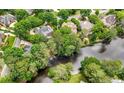 Aerial view of several homes nestled among lush greenery, backing onto a serene lake at 2743 Long Grove Dr, Marietta, GA 30062