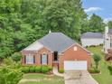 Charming brick home with a two-car garage, neat landscaping, and a walkway to the front door at 361 Brackin Trce, Grayson, GA 30017