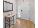 Entryway features a light wood floor, white trim, and a console table beneath a decorative mirror at 361 Brackin Trce, Grayson, GA 30017