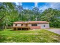 Ranch-style home featuring a red roof, brick foundation, and a wooden deck overlooking the grassy front yard at 428 Cornish Mountain Rd, Oxford, GA 30054