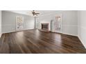 Cozy living room with fireplace, large windows, and new dark hardwood floors at 5659 Brookstone Nw Dr, Acworth, GA 30101