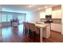 Open-concept kitchen with granite counters, stainless appliances, and a center island with seating at 2059 Lanier Harbor Pt, Buford, GA 30518