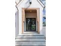 Stunning entryway featuring a custom black steel front door, natural wood accents, and gray stone steps at 6428 East Cherokee Dr, Canton, GA 30115