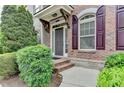 Inviting front porch with brick accents, manicured bushes, and a covered entryway at 7435 Jamestown Dr, Alpharetta, GA 30005