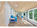 Open-concept living area with wood ceiling and large windows overlooking a wooded view at 135 Marina Ct, Canton, GA 30114