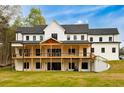 Rear view of home features a spacious wooden deck perfect for outdoor entertaining at 3180 Lee Dr, Buford, GA 30518