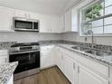 Close-up of the updated kitchen featuring a stainless-steel range and granite counters at 2628 Downingwood Ln, Grayson, GA 30017