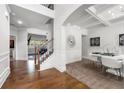 Welcoming foyer with hardwood floors, staircase, and an elegant dining area with white table and chairs at , Atlanta, GA 30349