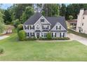 Lovely two-story home with black shutters, landscaping, and a well manicured lawn at 225 Ruby Forest Pkwy, Suwanee, GA 30024