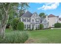 Two story home with landscaped yard, manicured shrubbery, black shutters, and neutral paint at 225 Ruby Forest Pkwy, Suwanee, GA 30024