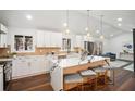 Modern kitchen featuring white cabinets, quartz countertops, pendant lighting and open to living room at 2541 Peyton Woods Sw Trl, Atlanta, GA 30311