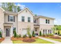 Charming townhomes featuring neutral brick, siding and trim, and professionally landscaped front yards at 320 Navigator Ln, Mcdonough, GA 30253