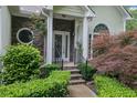Front Entrance with elegant stonework, arched window, and meticulously maintained landscaping at 4047 Watkins Glen Dr, Woodstock, GA 30189