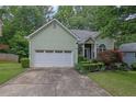Charming home with a two-car garage and manicured landscaping, lush green lawn, and mature trees at 4047 Watkins Glen Dr, Woodstock, GA 30189