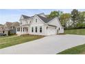 View of the side of a home showing a spacious driveway, two-car garage, and green lawn at 4060 Andover Cir, Mcdonough, GA 30252